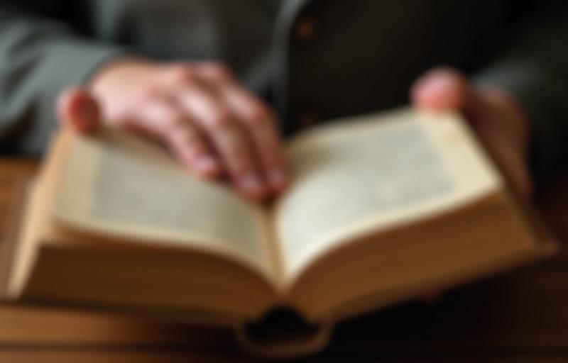 Inimene hoiab õrnalt lahtist vana raamatut mõlema käega, pöörates ettevaatlikult lehte.
